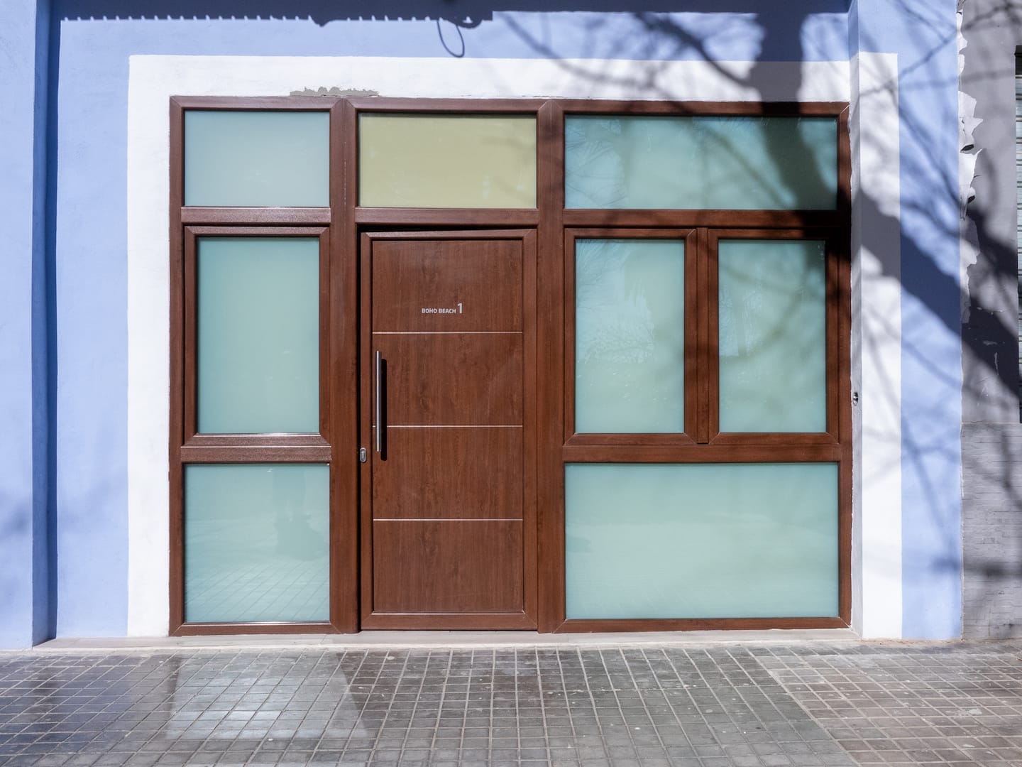 Wooden door of a studio in the blue façade